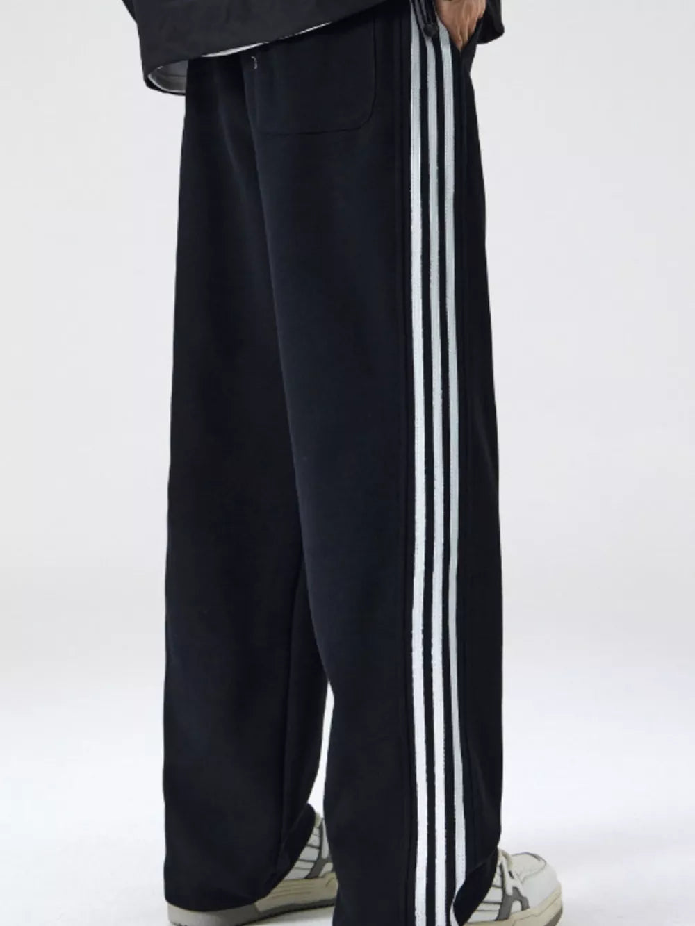 Black men's sweatpants with white side stripes and a relaxed fit.