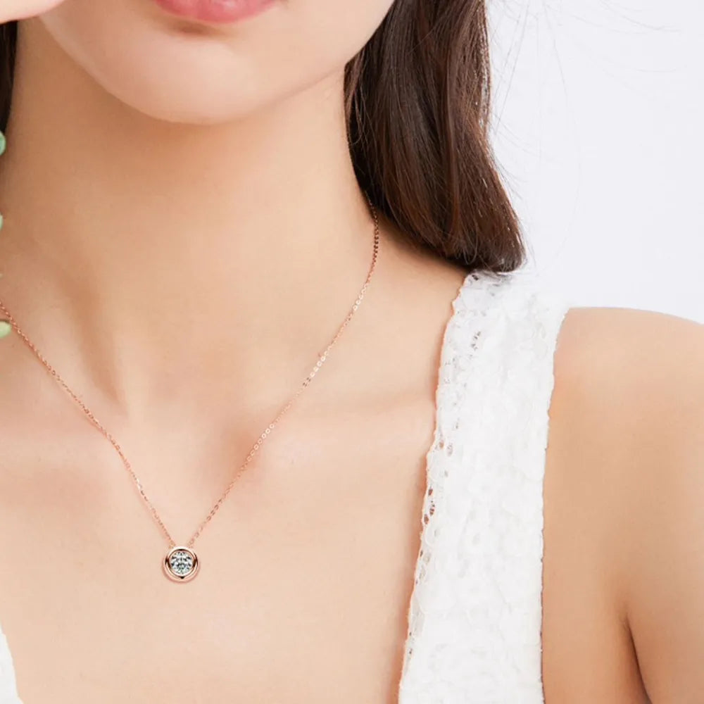 Rose gold solitaire pendant necklace with bezel-set diamond on a delicate chain.