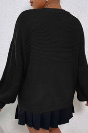 Black acrylic knit cardigan with textured yoke and balloon sleeves.