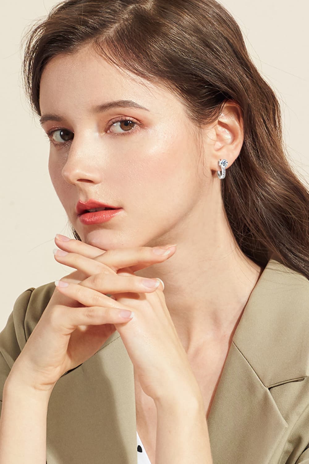 Silver pavé and solitaire hoop earrings worn by a woman.