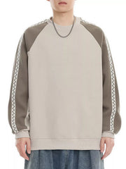 Oversized raglan sleeve sweatshirt in beige and gray with zigzag trim detail.