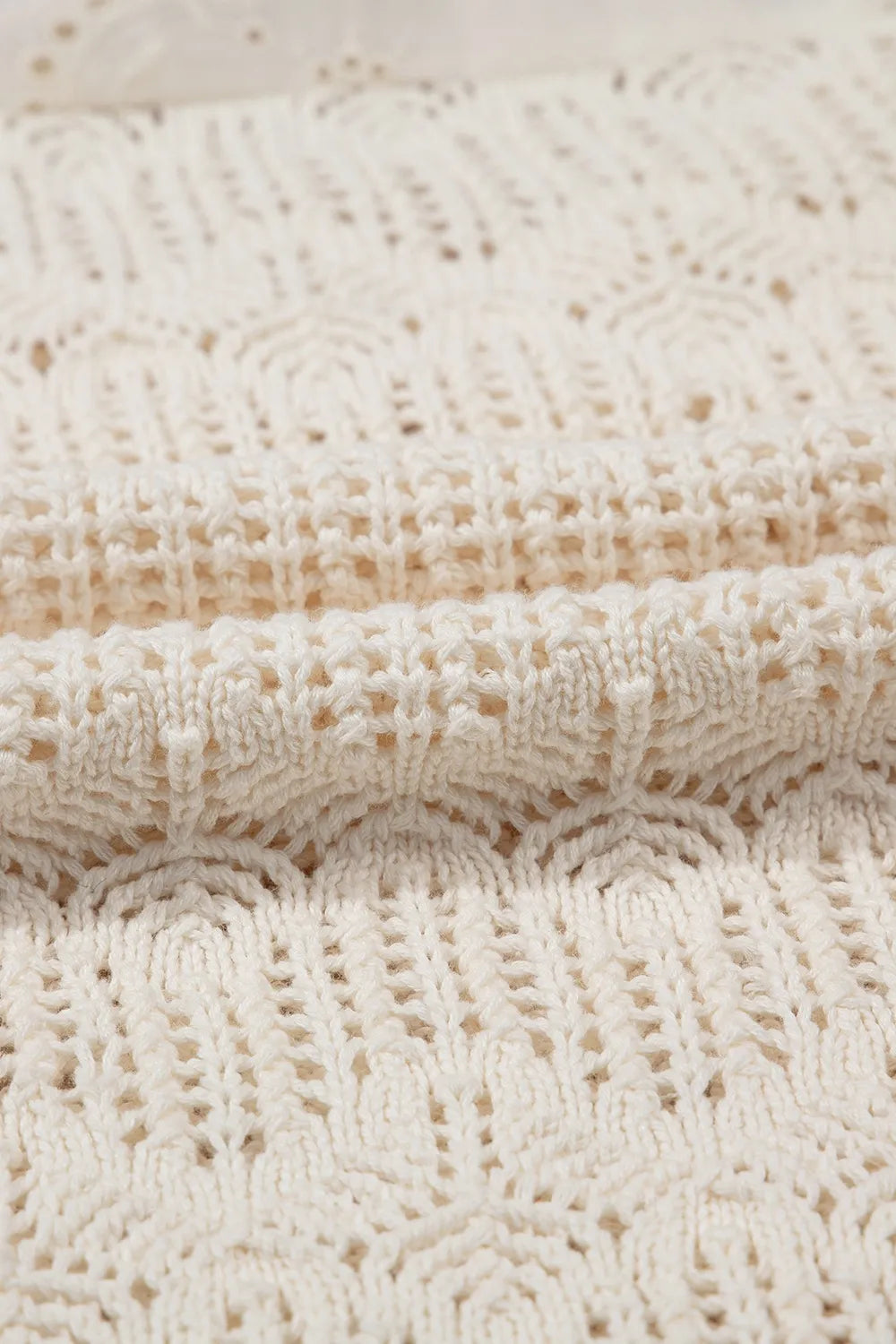 Beige crochet knit vest with eyelet yoke detail and open knit pattern.