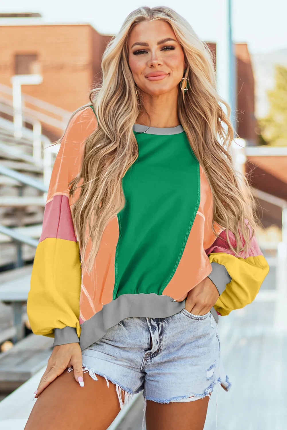 Colorblock paneled sweatshirt with green, tangerine, pink, and yellow panels, and gray trim.