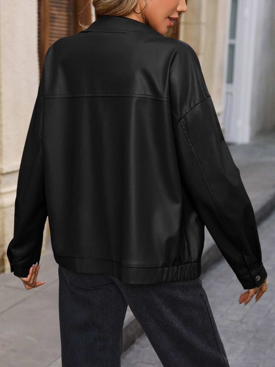 Black faux leather bomber jacket with elasticated hem and cuffs, shown from the back.