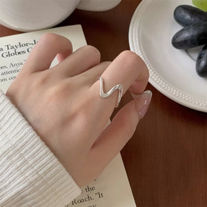 Wavy minimalist sterling silver ring with a modern, fluid design.
