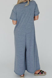 Denim-trimmed wide-leg utility jumpsuit in dusty blue with short sleeves and a relaxed fit.