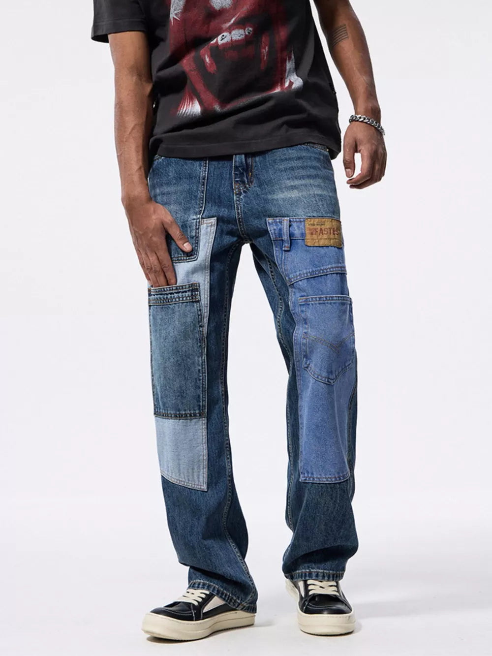 Relaxed fit patchwork jeans in blue denim with distressed details and cargo pockets.