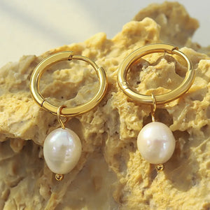 Gold hoop earrings with lustrous pearl drops and gold accents.