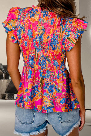 Smocked floral peplum top in hot pink with flutter sleeves and a ruffled hem.