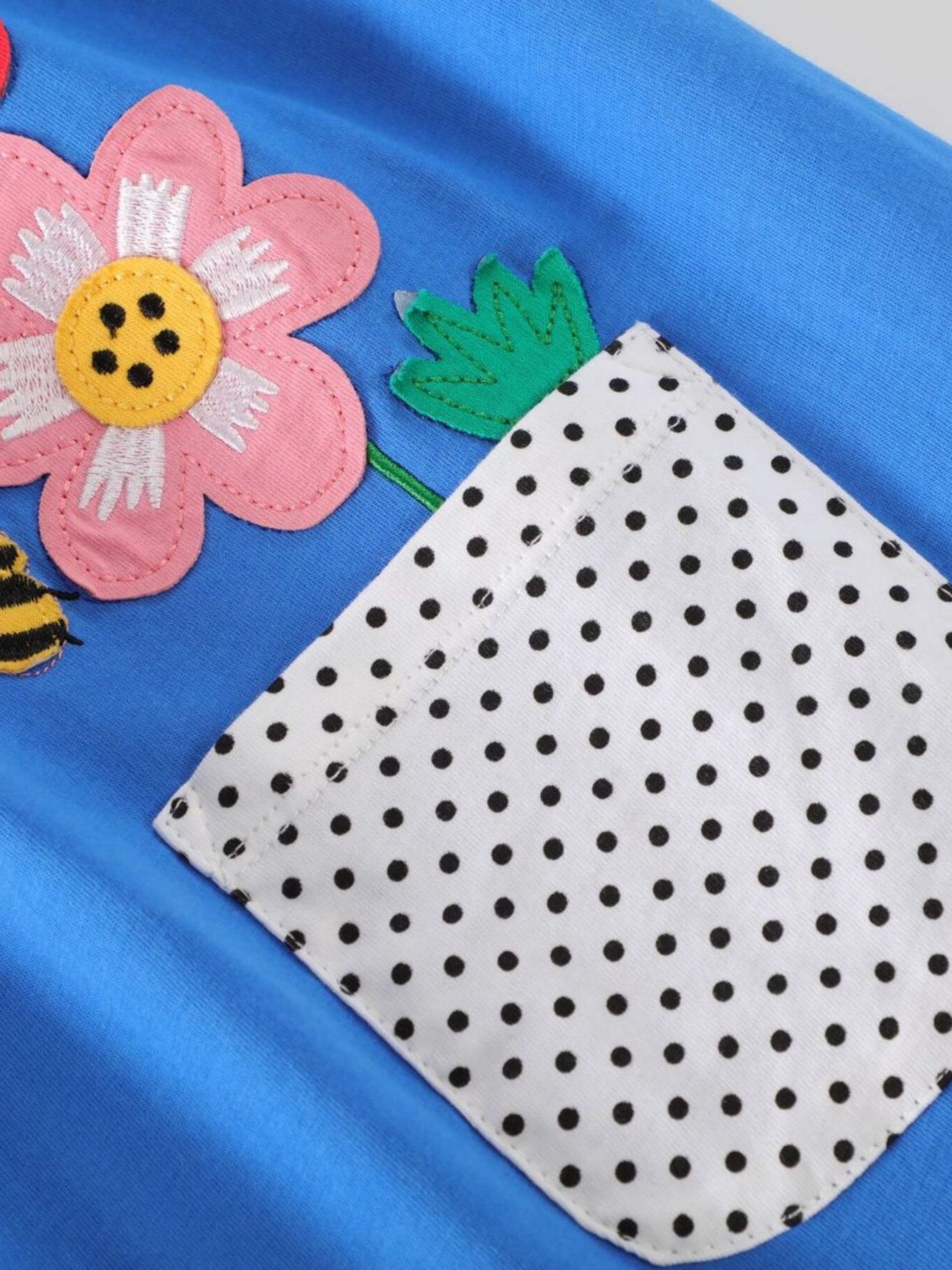 Blue cotton dress with pink flower, bee appliques, and polka dot pocket.