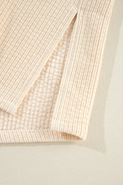 Beige corduroy utility jacket detail showing textured fabric and a side slit.