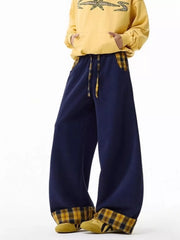 Navy blue wide-leg sweatpants with drawstring and plaid pocket accents and cuffs.