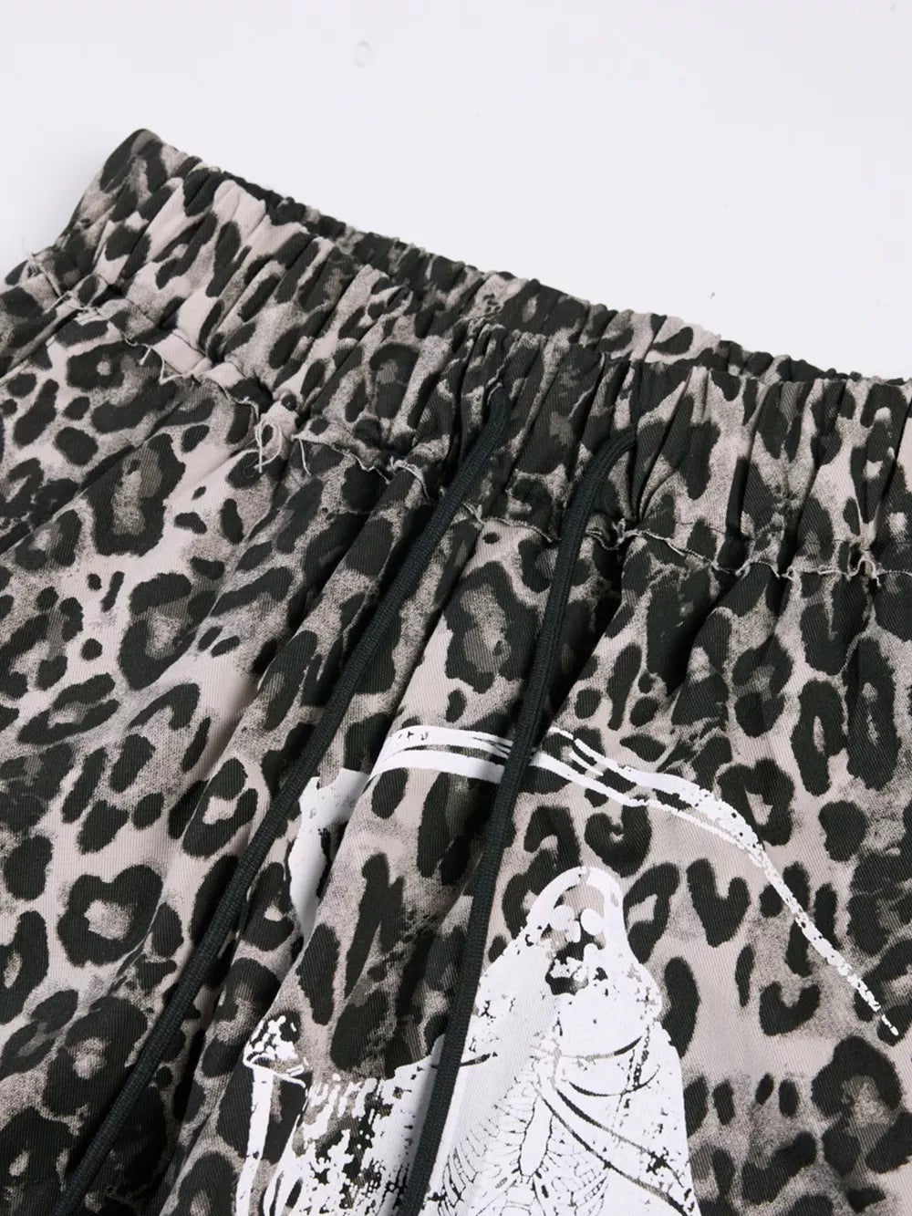 Leopard print cotton sweatpants with drawstring waist and graphic detail.