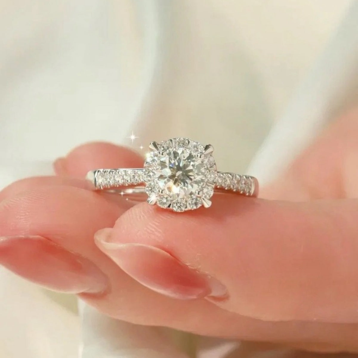 Sterling silver ring with brilliant moissanite center stone and halo detail.