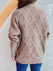Beige relaxed fit sweater with diamond cable knit pattern and mock neck.