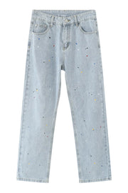 Light wash denim slouch trousers with colorful paint splatters and a straight leg cut.