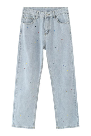 Light wash denim slouch trousers with colorful paint splatters and a straight leg cut.