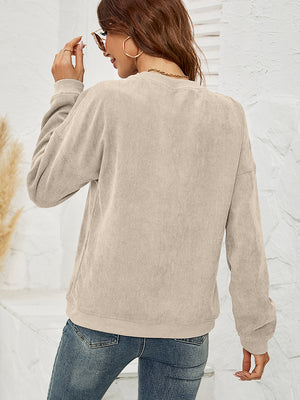 Tan corduroy crewneck sweatshirt with long sleeves and ribbed cuffs and hem.