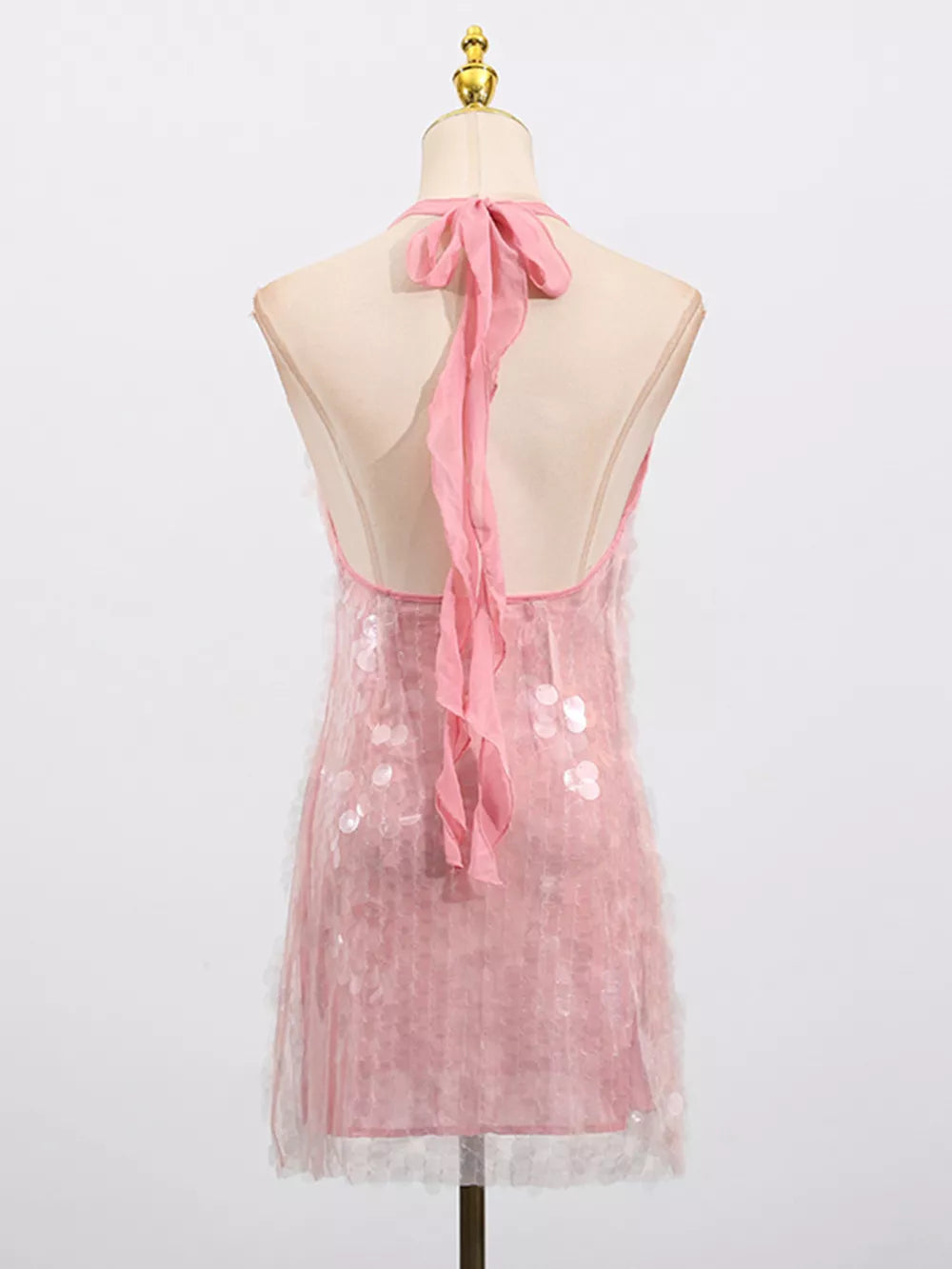 Pink sequin halter mini dress with sheer overlay and ribbon tie back.