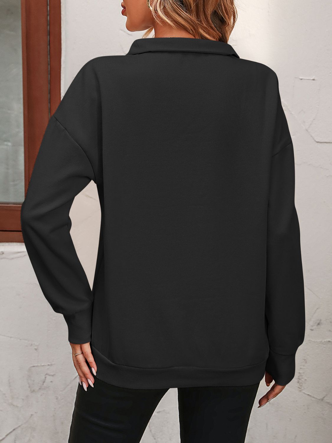 Black quarter-zip relaxed fit sweatshirt with a collar and long sleeves.