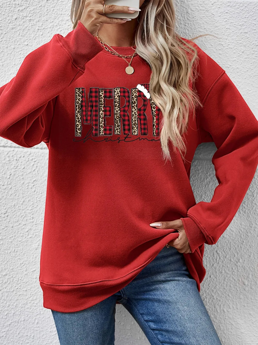 Red graphic sweatshirt with Merry Christmas text in buffalo plaid and leopard print.