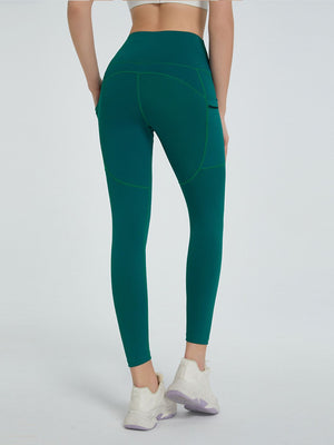Dark green pocketed sculpt leggings with contrast stitching and a high waist.