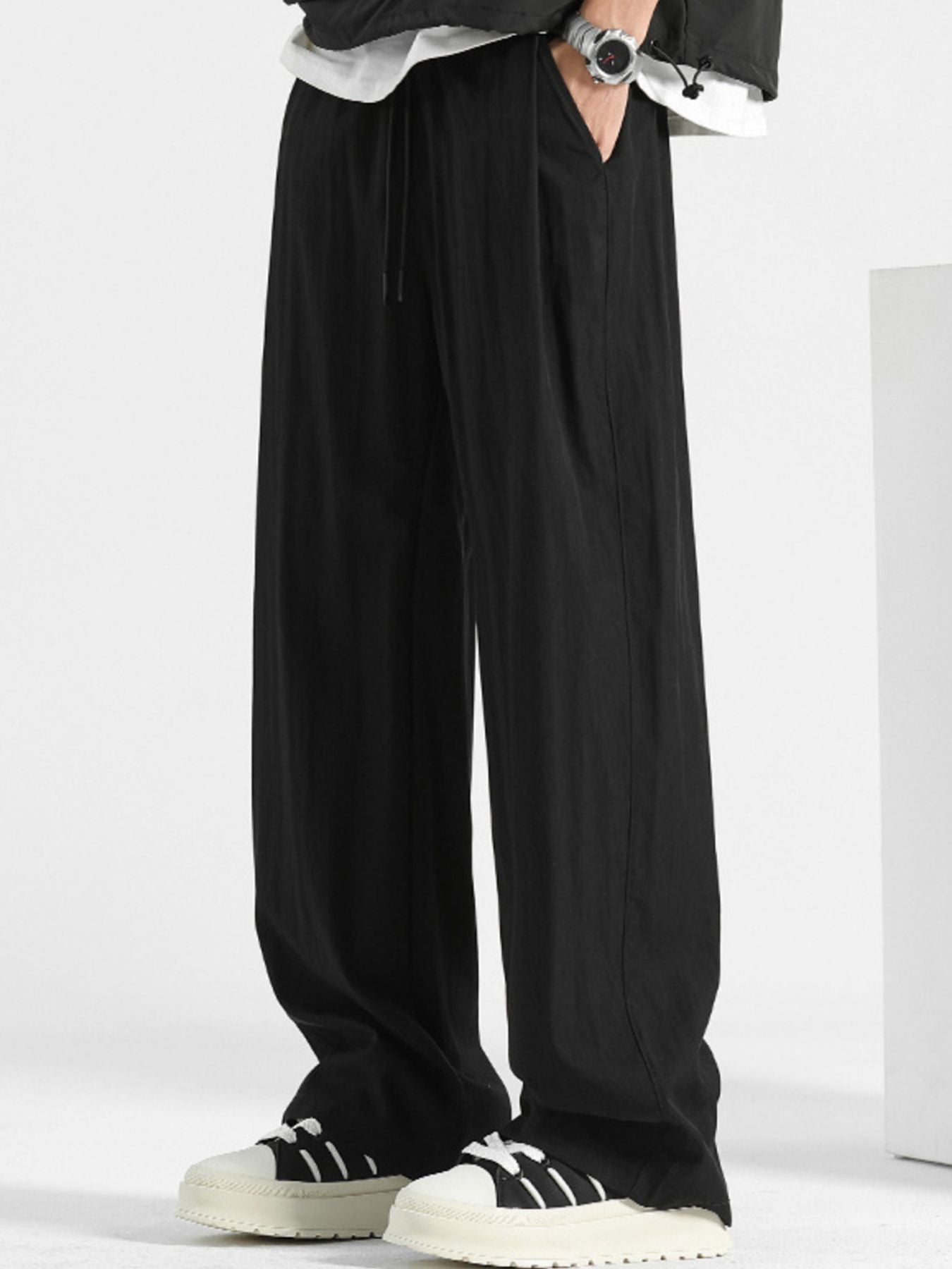 Black loose fit casual sweatpants with drawstring and elastic waistband.