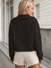 Black knit cardigan with frilled collar, long sleeves, and button front.