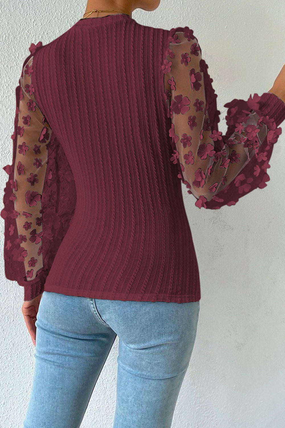 Wine knit top with sheer floral appliqué balloon sleeves and textured bodice.