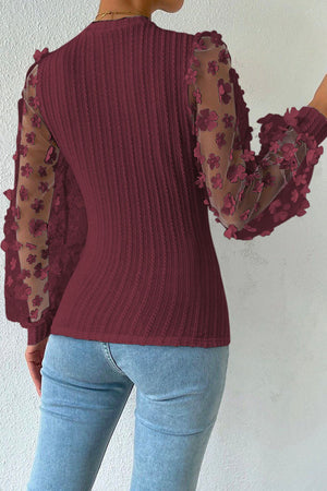 Wine knit top with sheer floral appliqué balloon sleeves and textured bodice.