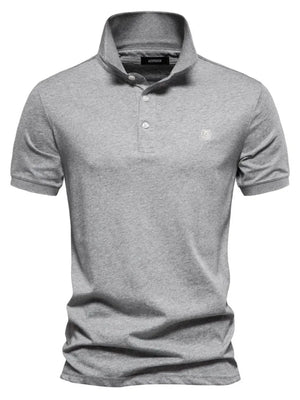Gray cotton polo shirt with embroidered crest detail and button placket.