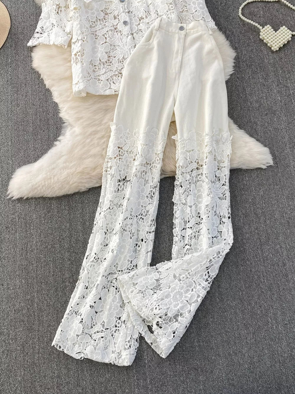 White lace two-piece set with button-up collared top and wide-leg pants with lace trim.