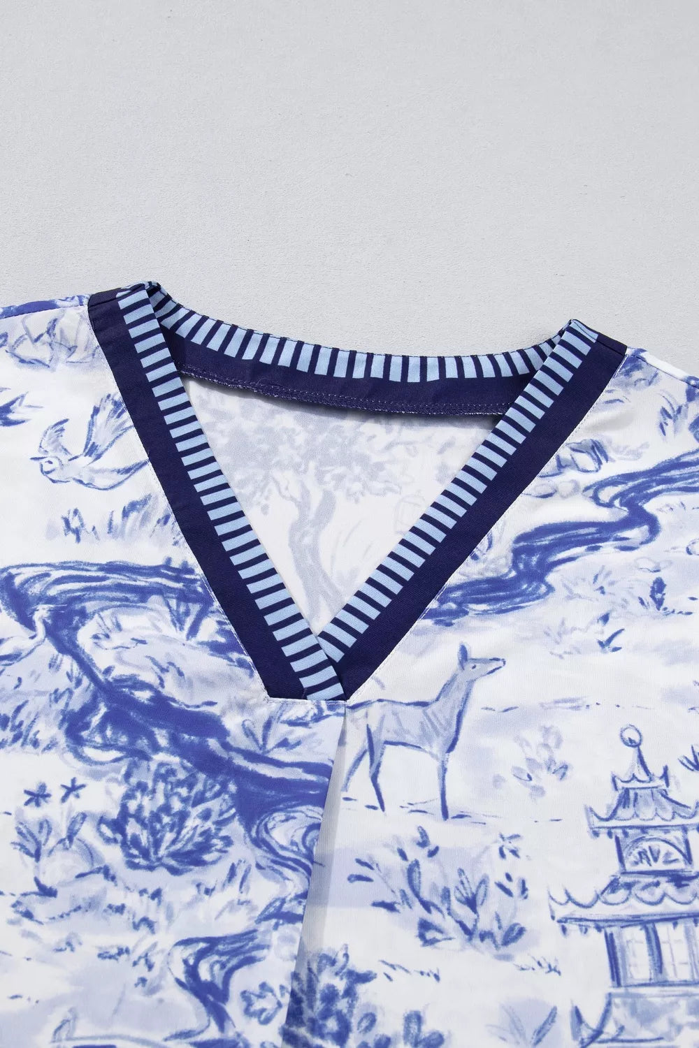 Blue toile print v-neck blouse with striped collar detail and deer motif