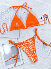 Tangerine bikini set with leopard print bottoms and tie sides.