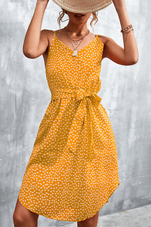 Mustard daisy print slip dress with tie waist and V-neck.