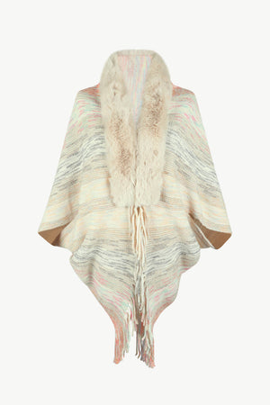Textured knit cape with faux fur collar and fringe detail in a multi-color stripe pattern.