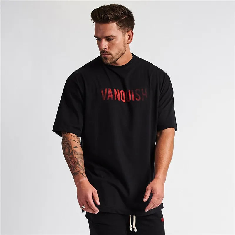 Black oversized t-shirt with red gradient "Vanquish" graphic print and short sleeves.