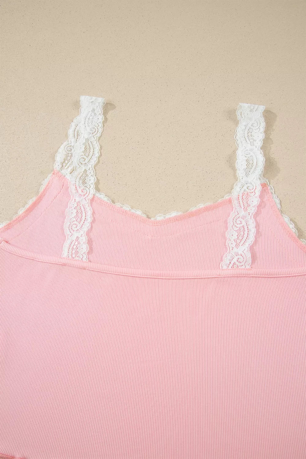 Pink ribbed cami pajama top with white lace trim straps and neckline.