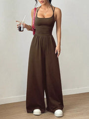 Brown ruched wide-leg jumpsuit with spaghetti straps and a square neckline.
