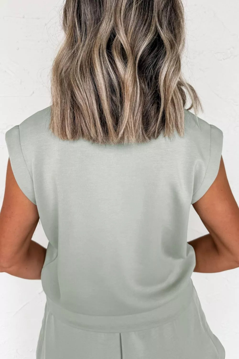 Light green activewear set with padded shoulders and banded hem.