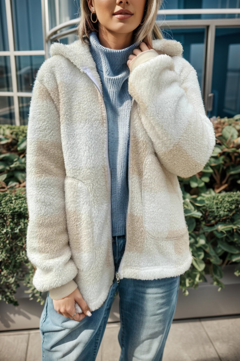 Sherpa zip-up jacket with buffalo check pattern in cream and tan, featuring a hood and pockets.