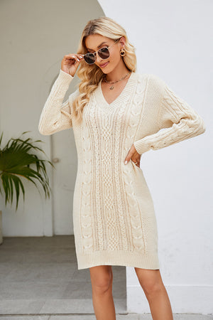 Cream cable knit bodycon mini dress with V-neck and long sleeves.