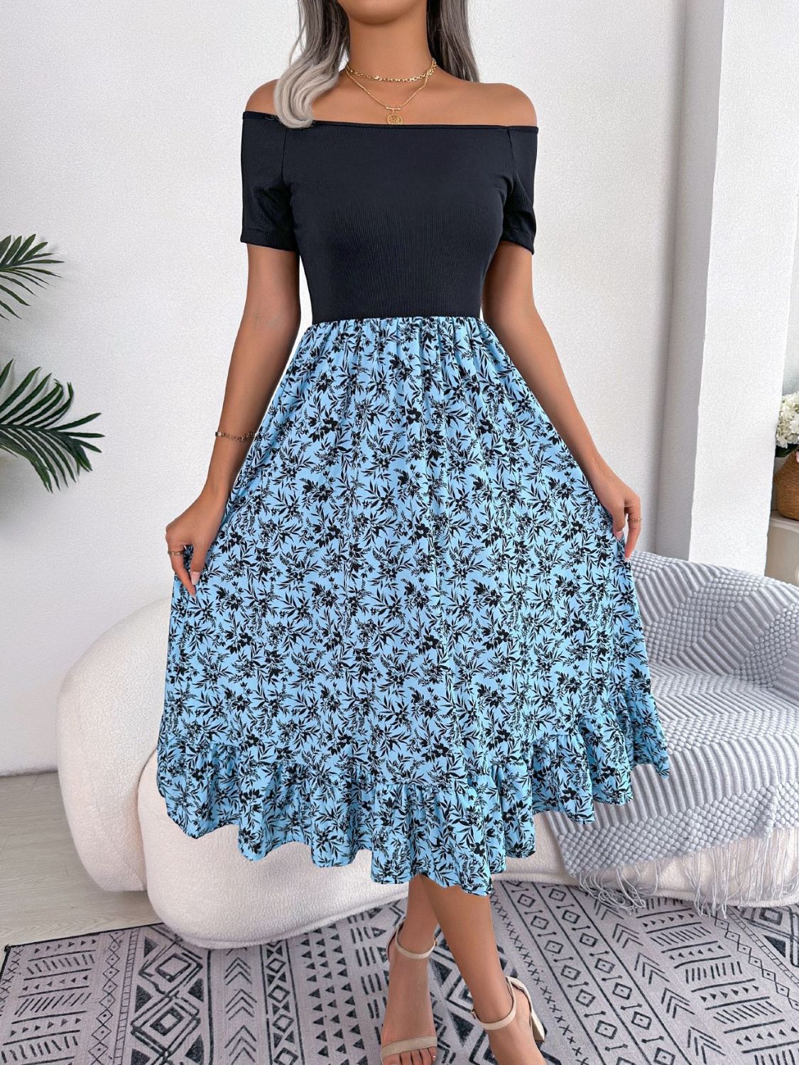 Floral print off-shoulder midi dress in sky blue with black floral pattern and ruffled hem.