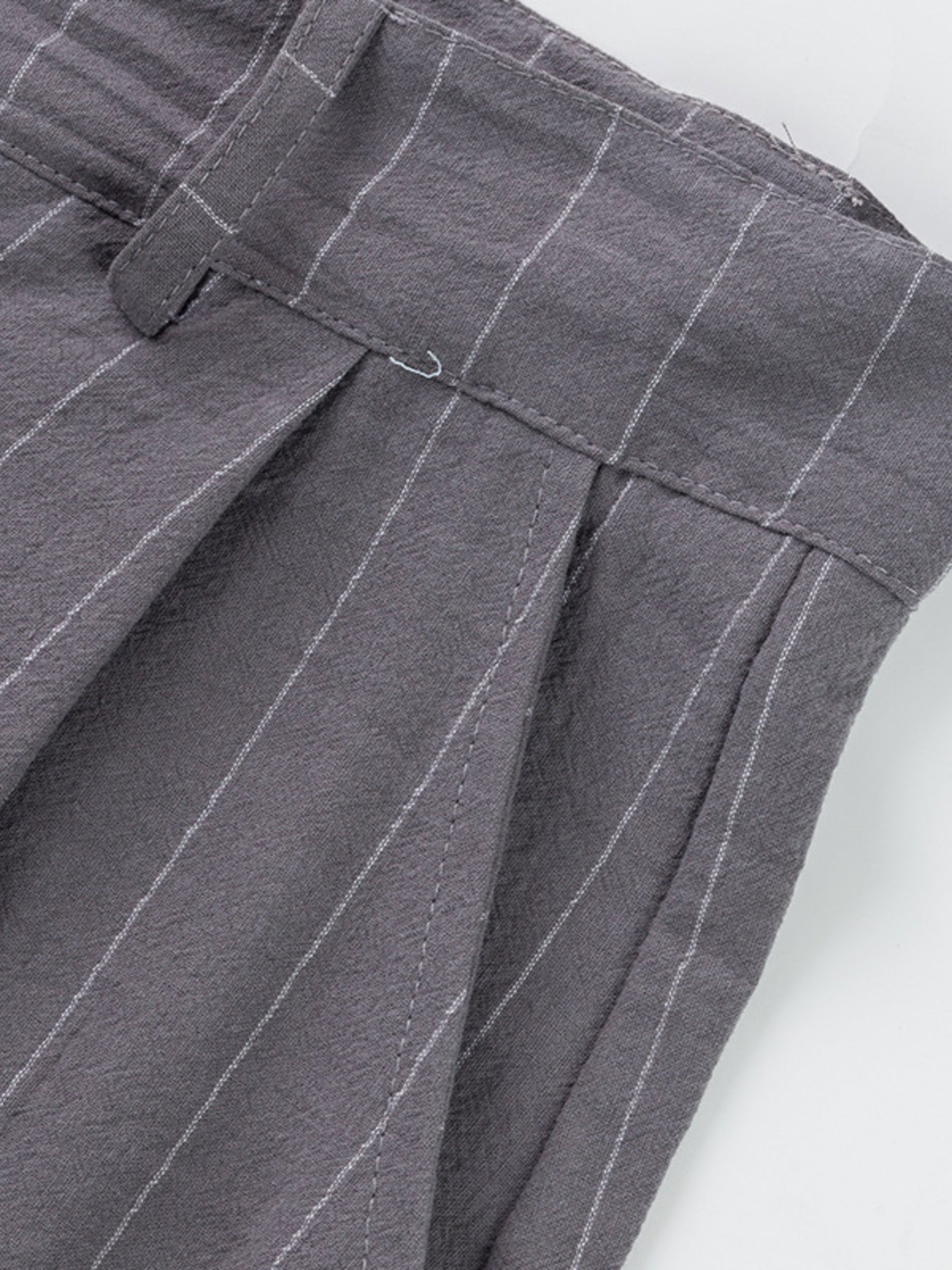 Grey pinstripe sweatpants with pleats and a belted waist detail.