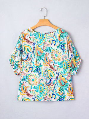 Paisley floral puff sleeve blouse with a round neckline in white with blue, green, yellow, and brown print.