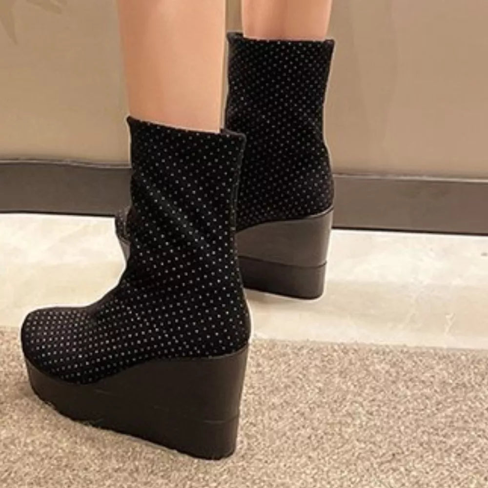 Black polka dot suede wedge boots with platform and wedge heel.