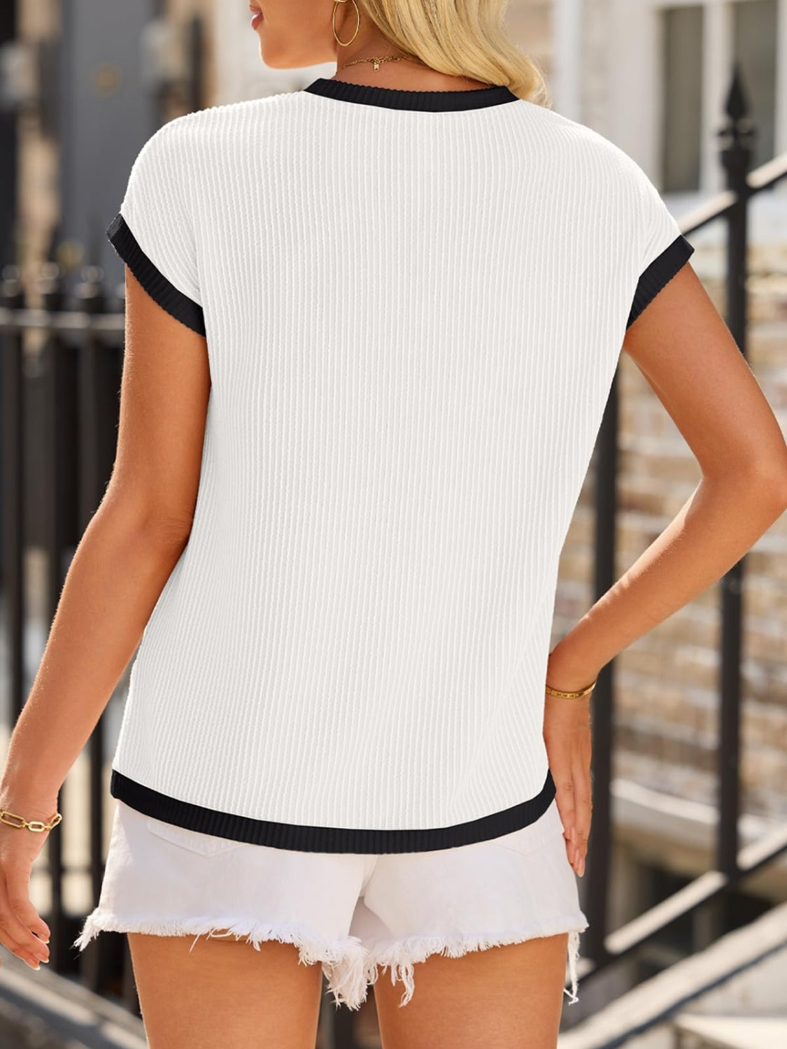 White ribbed knit tee with black contrast piping on neckline and hem.