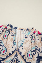 Paisley print blouse in ivory with a V-neck and slit sleeves.