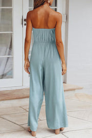 Light blue bandeau jumpsuit with wide legs and cinched waist detail.