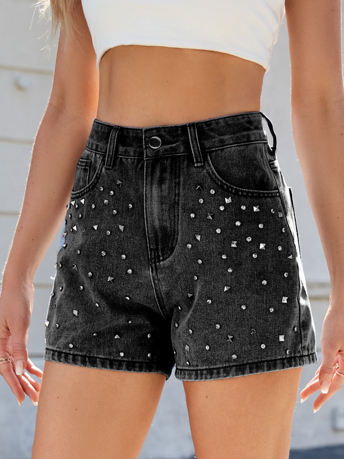 Black studded denim high-waisted cutoff shorts with a distressed wash.